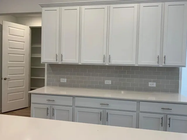 a kitchen with white cabinets and a sink