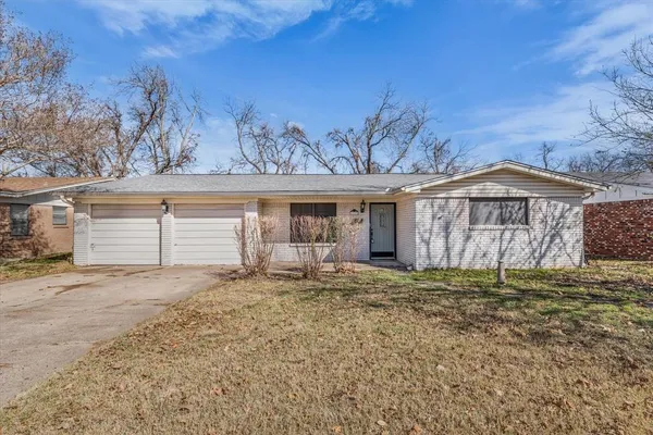 a view of a house with a yard and wooden fence