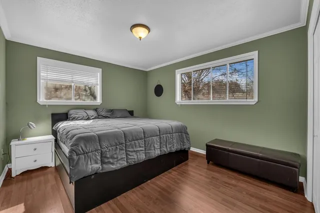 a bedroom with a bed and a painting on the wall