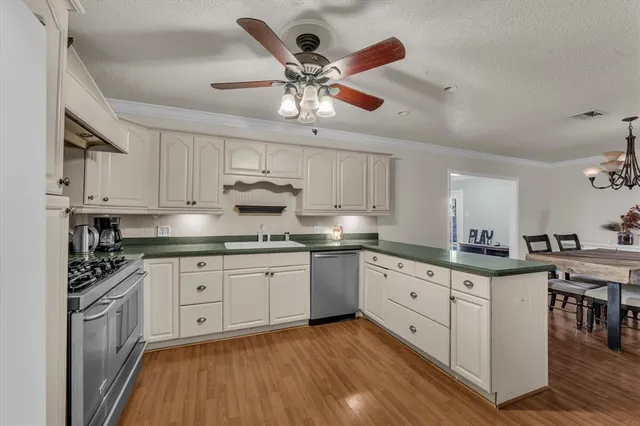 a kitchen with granite countertop a sink cabinets stainless steel appliances and a counter space