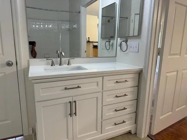 a bathroom with a sink vanity and mirror