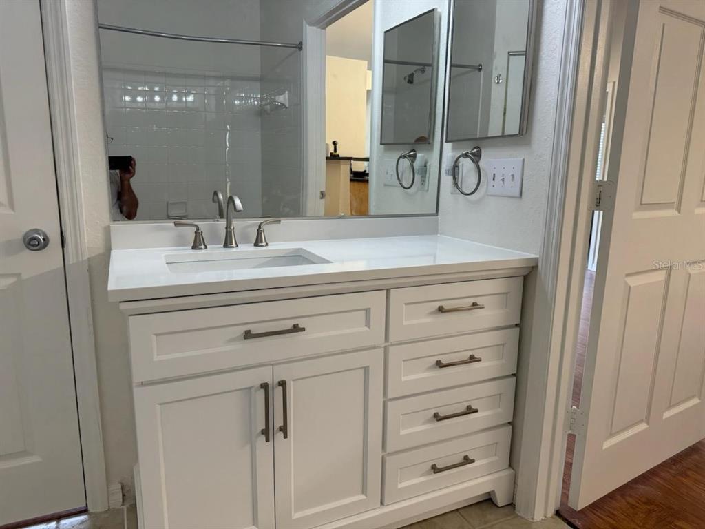 3648 Kings Road, Unit 103 Palm Harbor, FL 34685 - Photo 8 of 26 a bathroom with a sink vanity and mirror