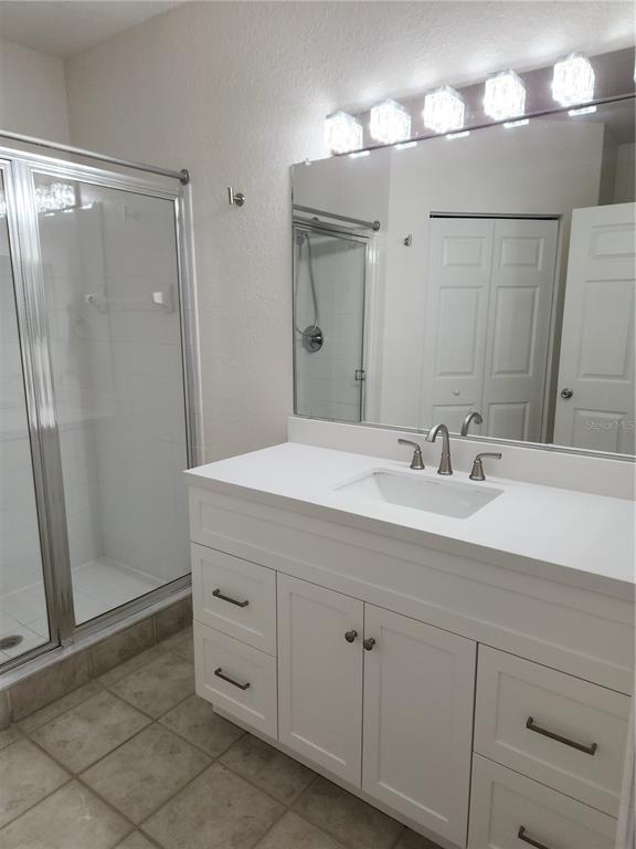 3648 Kings Road, Unit 103 Palm Harbor, FL 34685 - Photo 10 of 26 a bathroom with a double vanity sink mirror and shower