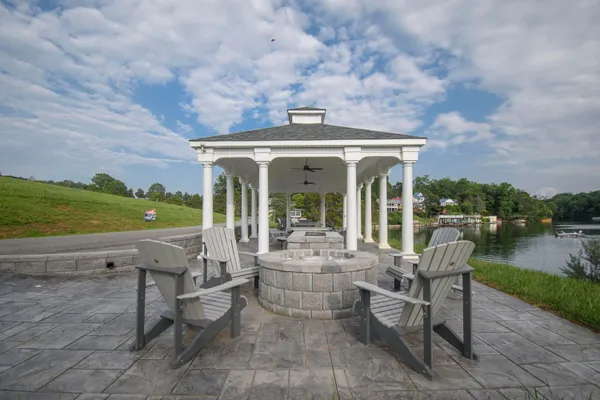a view of a patio with lawn chairs floor to ceiling window and lake view