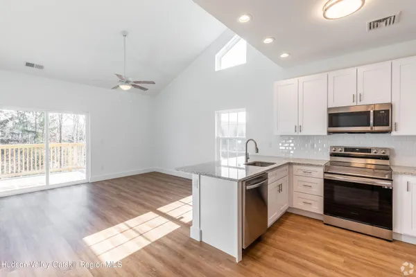 a kitchen with granite countertop a stove top oven and cabinets