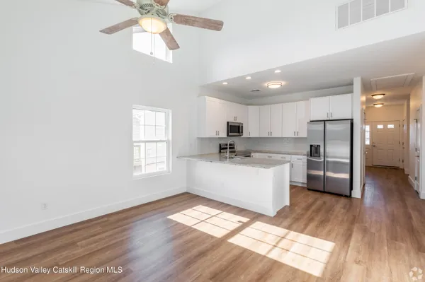 a kitchen with stainless steel appliances a refrigerator a sink dishwasher with a oven and wooden floor