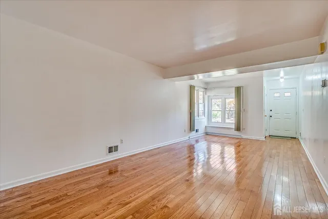 a view of a kitchen with a refrigerator a ceiling fan and wooden floor