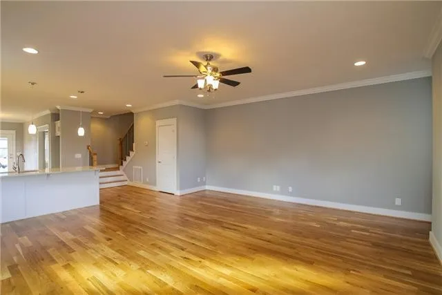a view of an empty room with chandelier fan and fire place