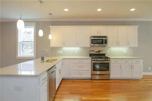 a kitchen with granite countertop a stove a sink and a microwave