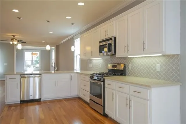 a kitchen with granite countertop white cabinets and white appliances