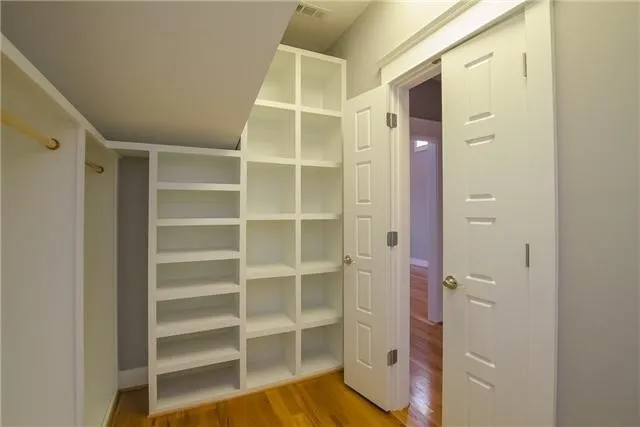 a view of walk in closet with empty racks