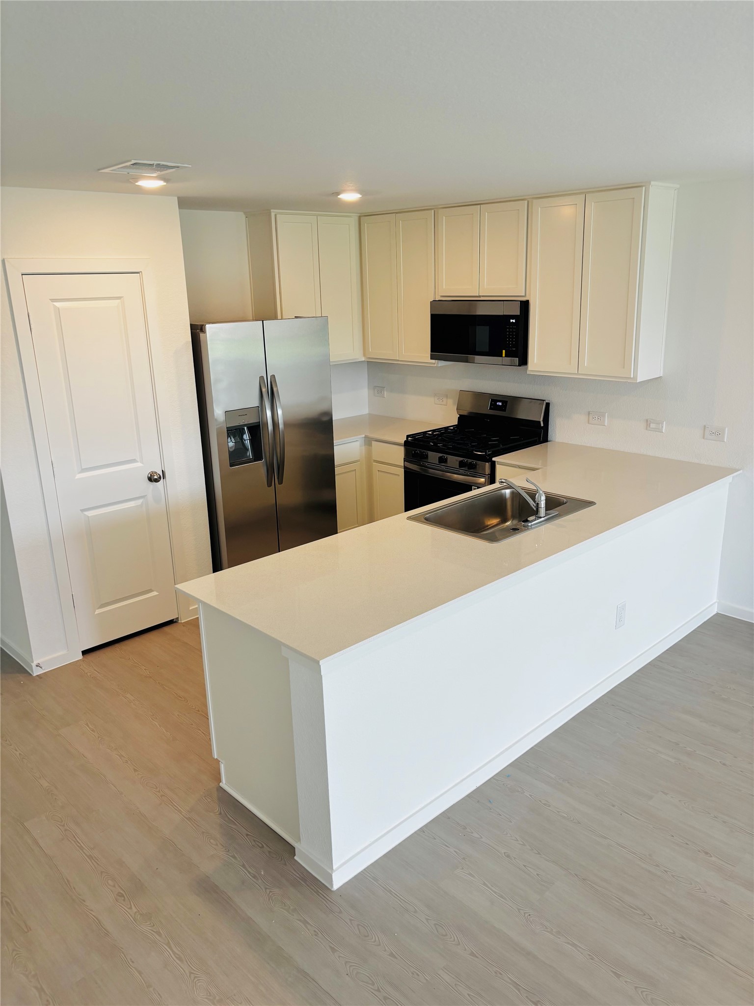 2126 Mosaic Vly Court Angleton, TX 77515 - Photo 10 of 40 a kitchen with stainless steel appliances a refrigerator a sink a stove a microwave and cabinets