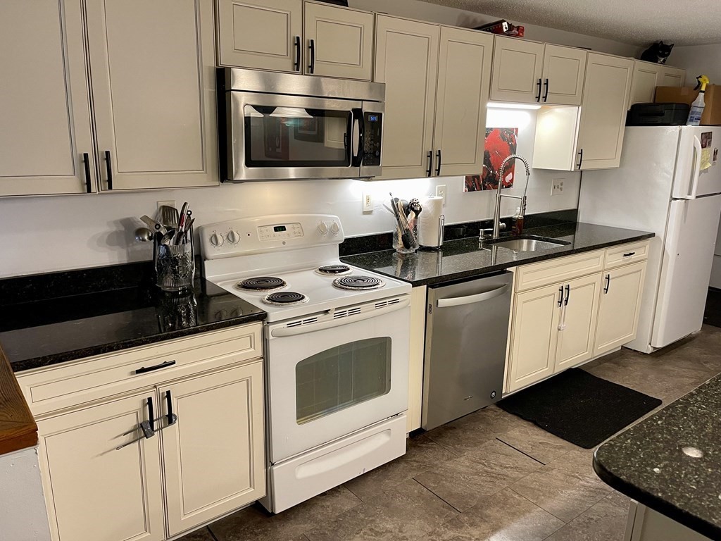 2 Oden Avenue, Unit 3 Worcester, MA 01604 - Photo 2 of 9 a kitchen with granite countertop a sink stainless steel appliances and white cabinets