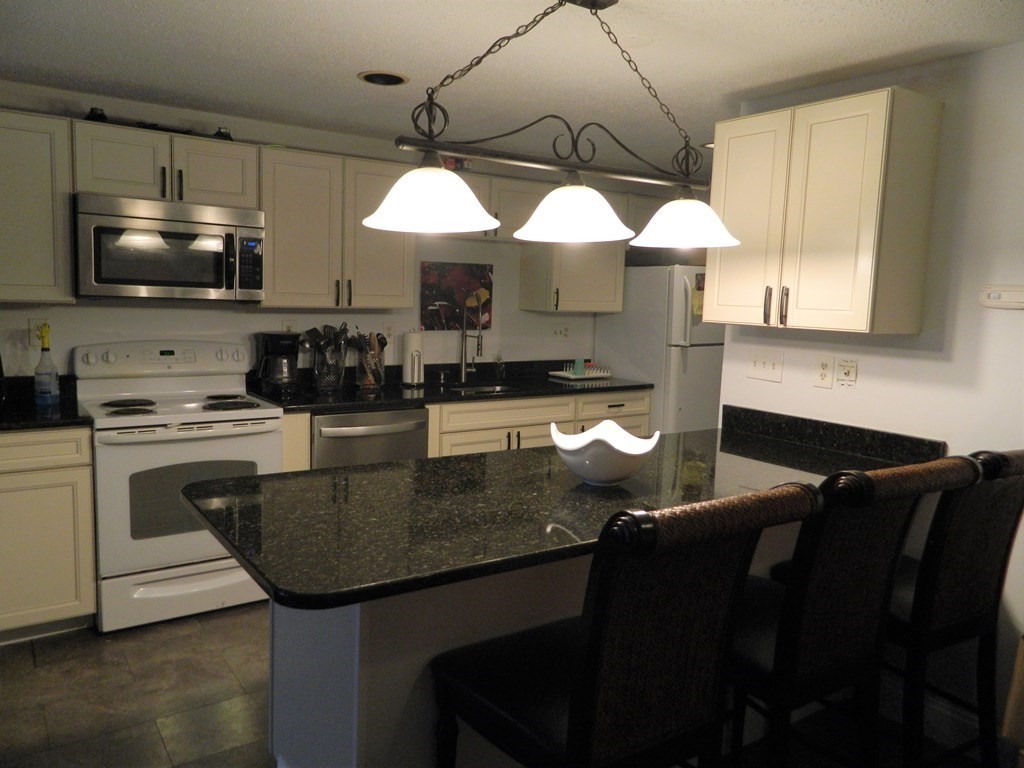 2 Oden Avenue, Unit 3 Worcester, MA 01604 - Photo 3 of 9 a kitchen with stainless steel appliances granite countertop a stove a sink and a microwave