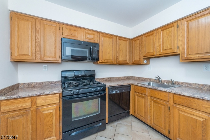 71 Patriots Road Morris Plains, NJ 07950 - Photo 8 of 18 a kitchen with granite countertop wooden cabinets and a stove top oven