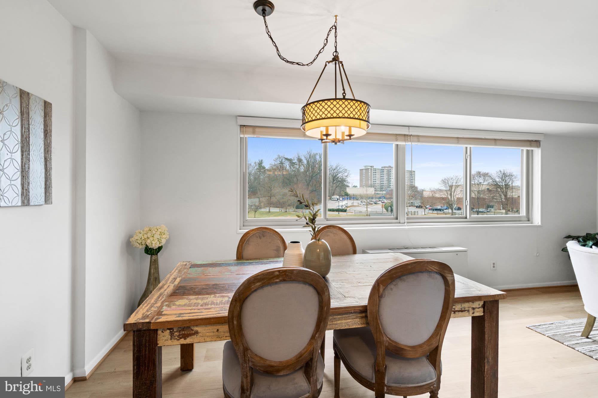 5100 Dorset Avenue, Unit 111 Chevy Chase, MD 20815 - Photo 22 of 38 a view of a dining room with furniture chandelier and wooden floor