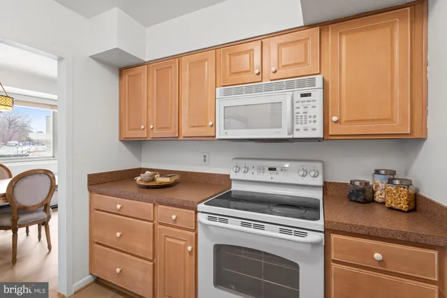 a kitchen with stainless steel appliances granite countertop a stove and a white cabinets