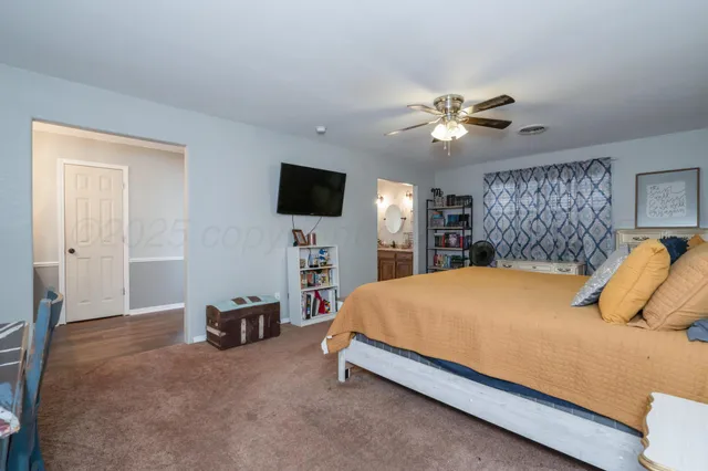 a bedroom with a bed and a flat tv screen on dresser