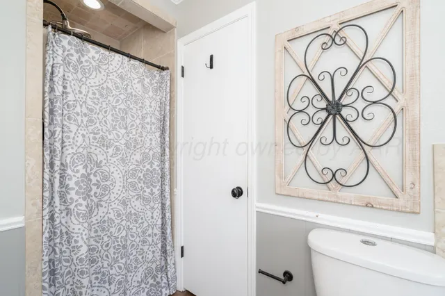 a bathroom with a shower curtain and a sink with window