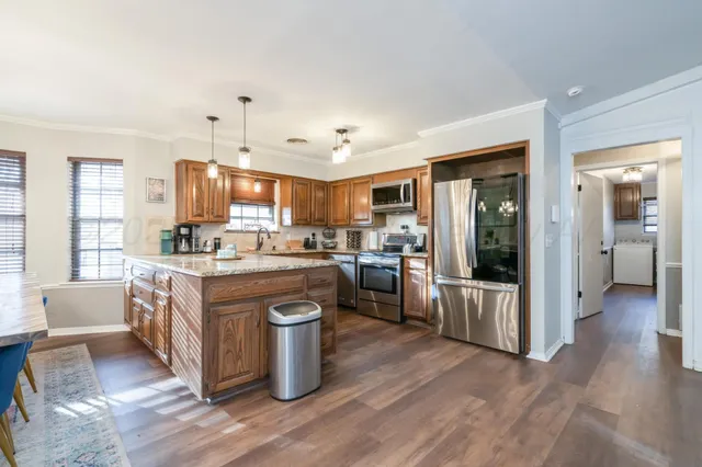 a kitchen with stainless steel appliances granite countertop wooden floors and sink