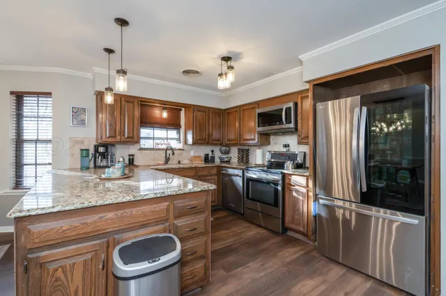 a kitchen with kitchen island granite countertop a sink stove and refrigerator