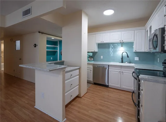 a kitchen with a sink cabinets and wooden floor