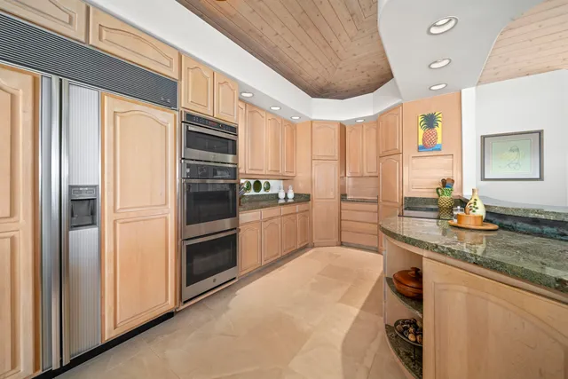 a kitchen with white cabinets and refrigerator