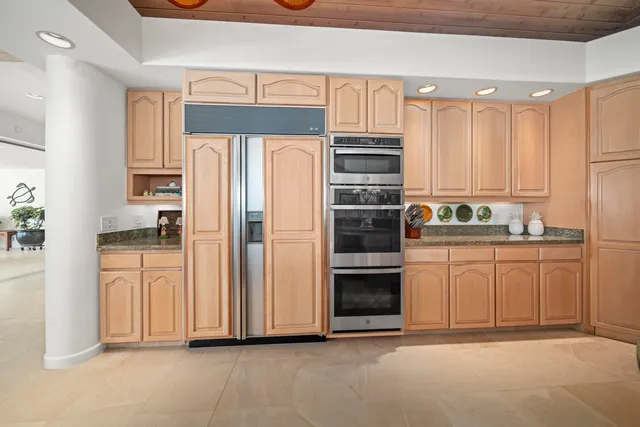 a kitchen with stainless steel appliances granite countertop a sink a stove and a wooden floors
