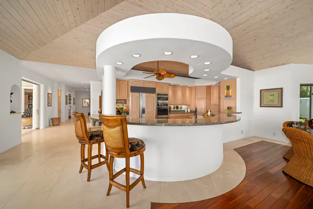 a dining hall with stainless steel appliances a dining table and chairs with wooden floor