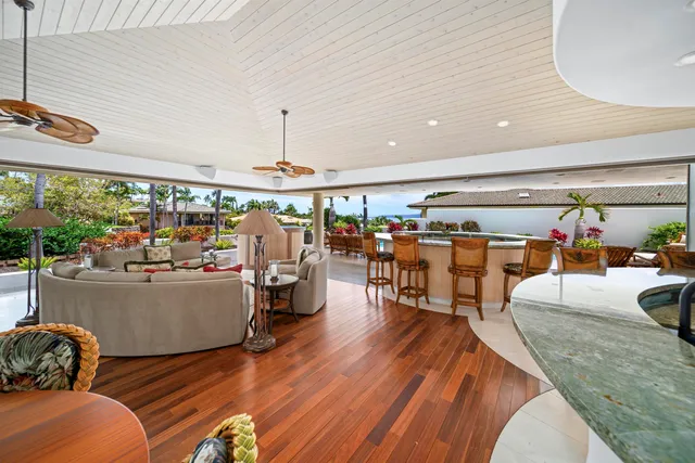 a large living room with stainless steel appliances granite countertop furniture wooden floor and a rug