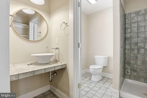 a bathroom with a sink a mirror a toilet and a shower