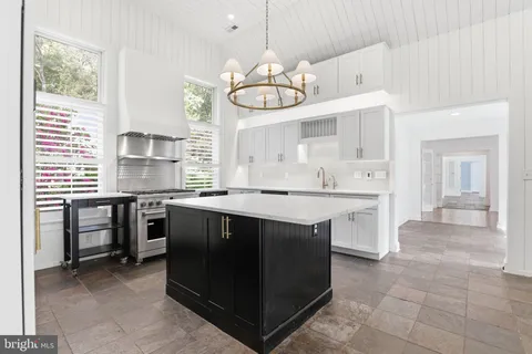 a kitchen with kitchen island granite countertop a sink and a stove