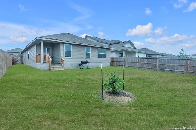 a view of a house with a yard and sitting area