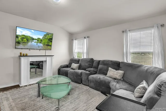 a living room with furniture a fireplace and a flat screen tv