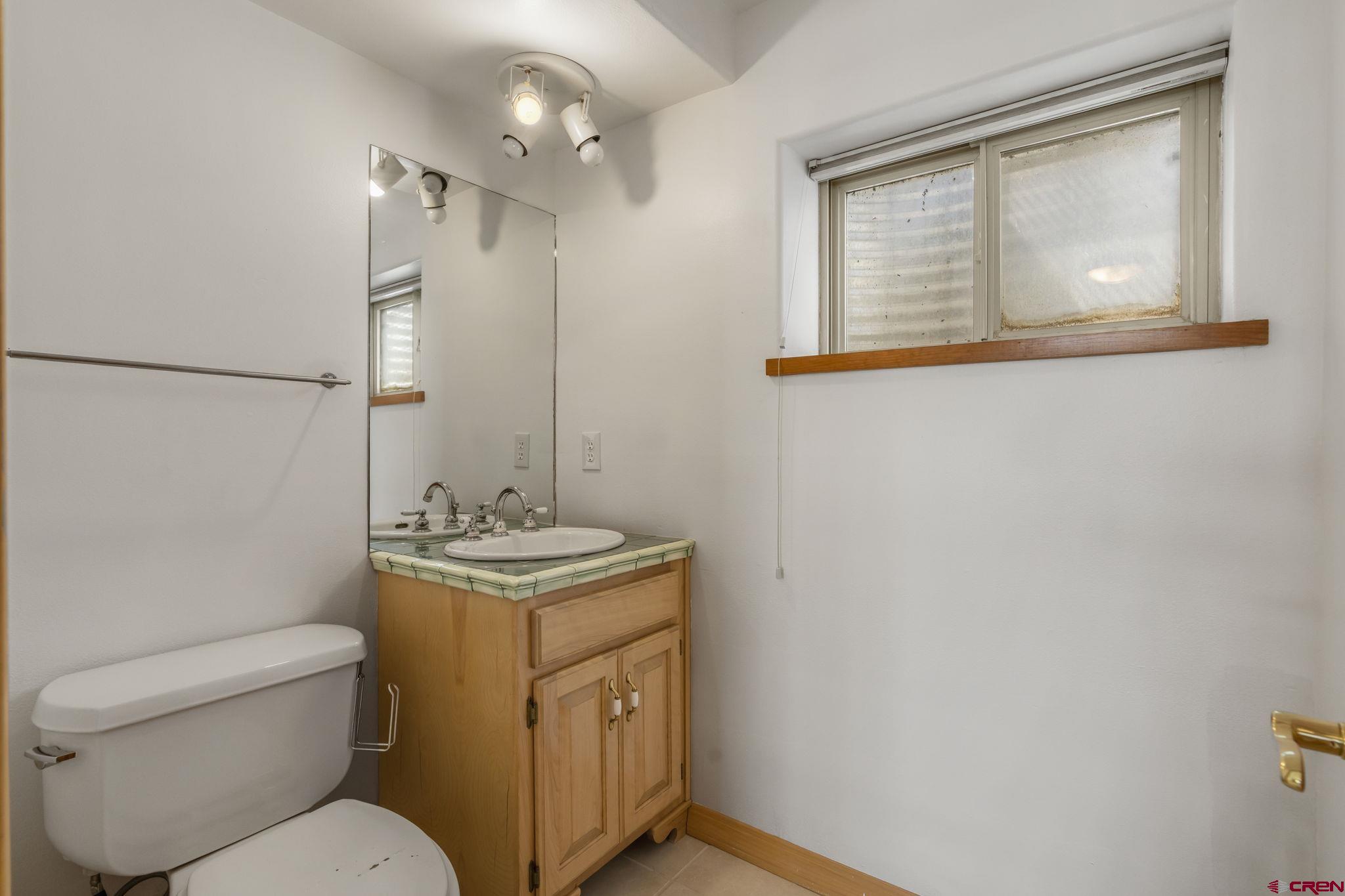 2015 West 3rd Avenue Durango, CO 81301 - Photo 6 of 32 a bathroom with a granite countertop toilet a sink and a mirror