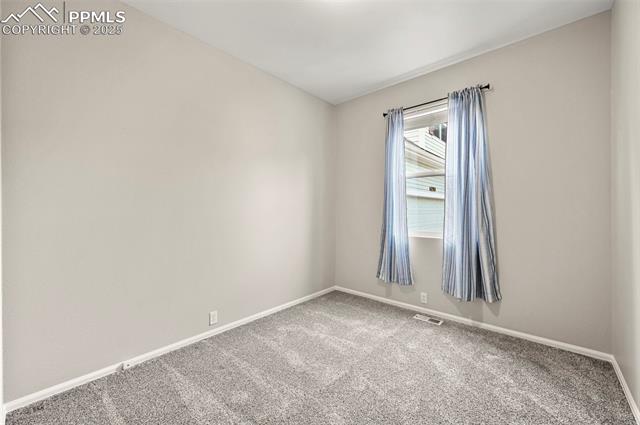 11927 Rodez Grove Peyton, CO 80831 - Photo 23 of 34 Carpeted spare room featuring baseboards and visible vents