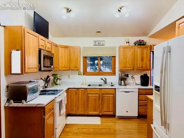 a kitchen that has a table chairs in it and wooden cabinets