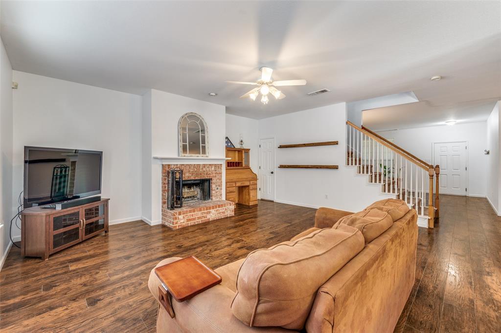 2516 Quail Ridge Road Melissa, TX 75454 - Photo 12 of 30 a view of a livingroom with furniture a fireplace wooden floor and chandelier