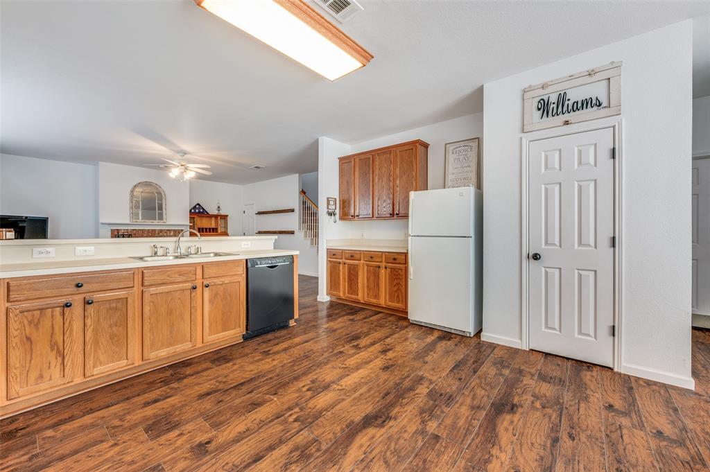 2516 Quail Ridge Road Melissa, TX 75454 - Photo 17 of 30 a kitchen with a refrigerator a stove top oven a white cabinets and wooden floor