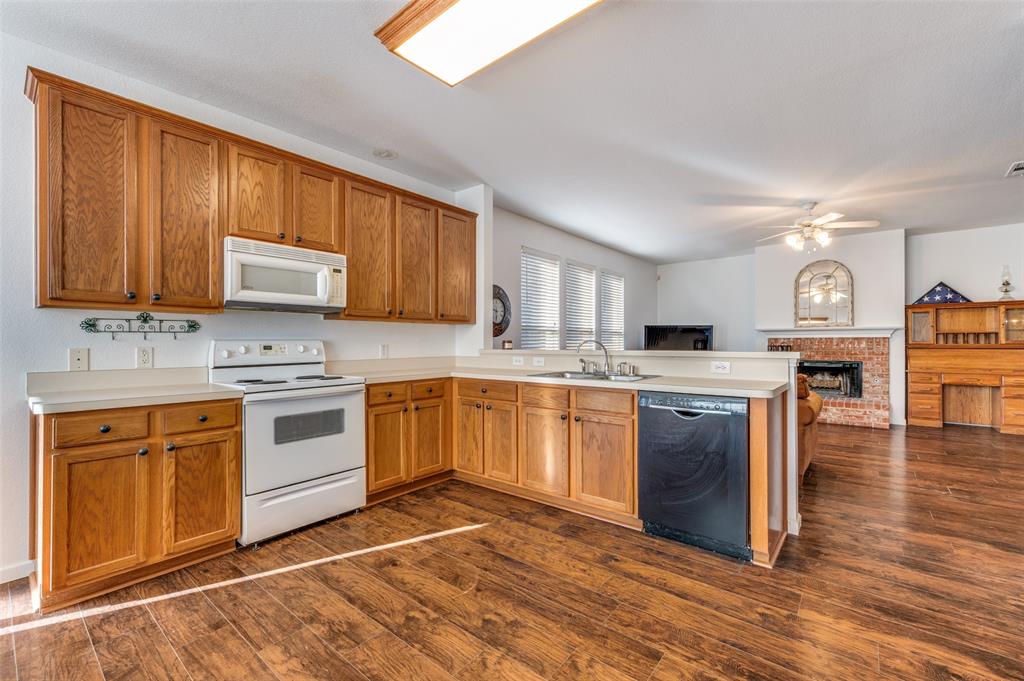 2516 Quail Ridge Road Melissa, TX 75454 - Photo 18 of 30 a kitchen with stainless steel appliances granite countertop a stove top oven a sink dishwasher and granite countertops with wooden floor