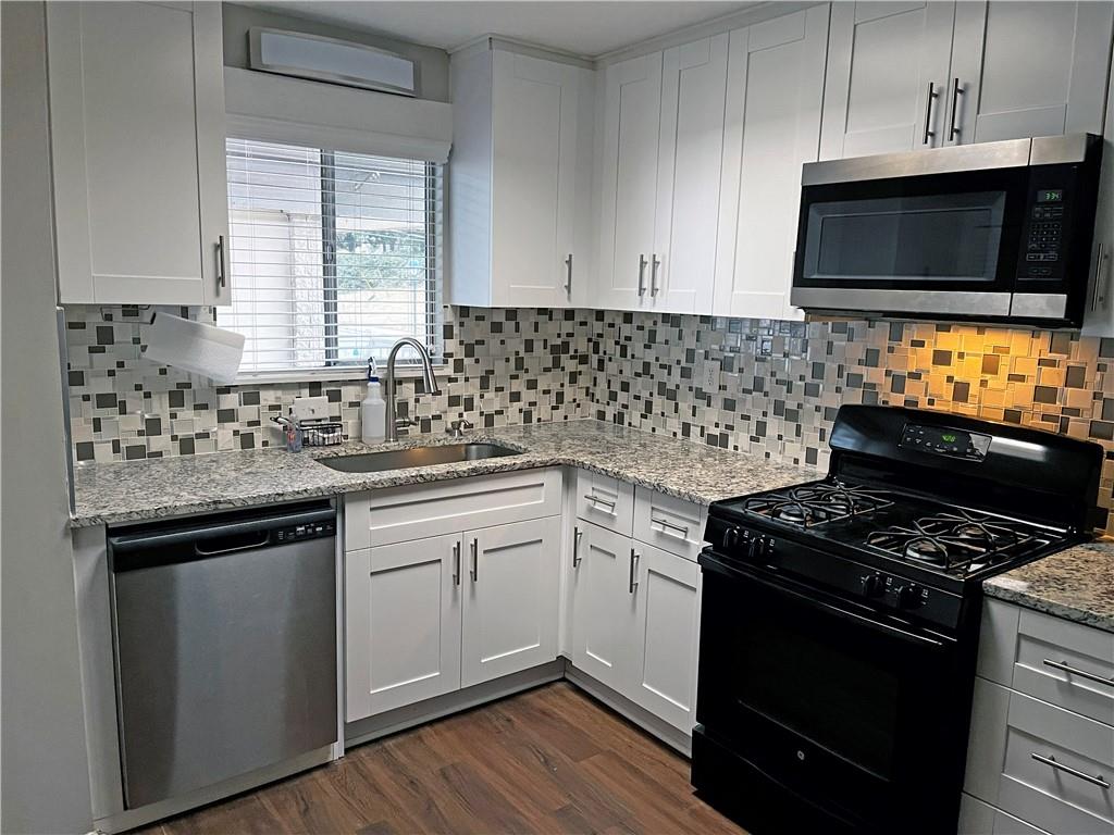 346 Carpenter Drive Northeast, Unit 7 Atlanta, GA 30328 - Photo 3 of 16 a kitchen with stainless steel appliances a sink dishwasher stove microwave and cabinets