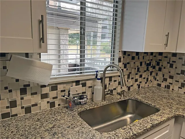a kitchen with a sink and a white wooden cabinets