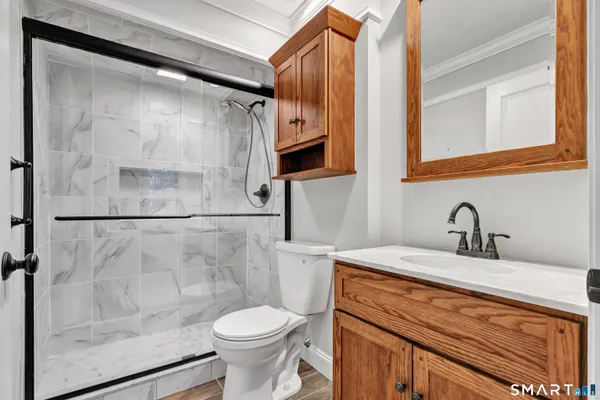 a bathroom with a sink a toilet and shower