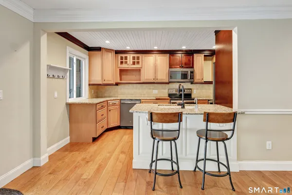a kitchen with stainless steel appliances kitchen island granite countertop a sink and cabinets