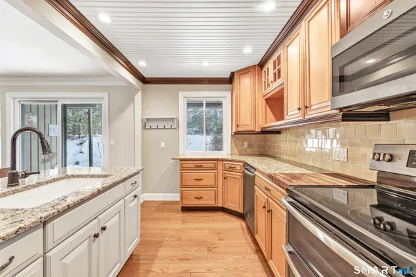 a large kitchen with stainless steel appliances granite countertop a stove and a sink