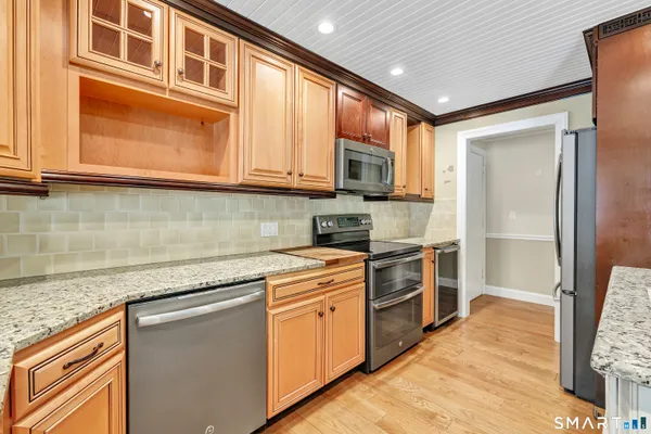 a kitchen with stainless steel appliances granite countertop a stove a sink and a refrigerator