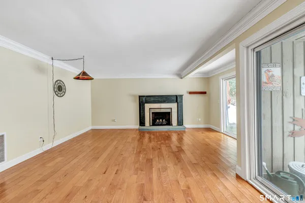 a view of empty room with wooden floor and fireplace