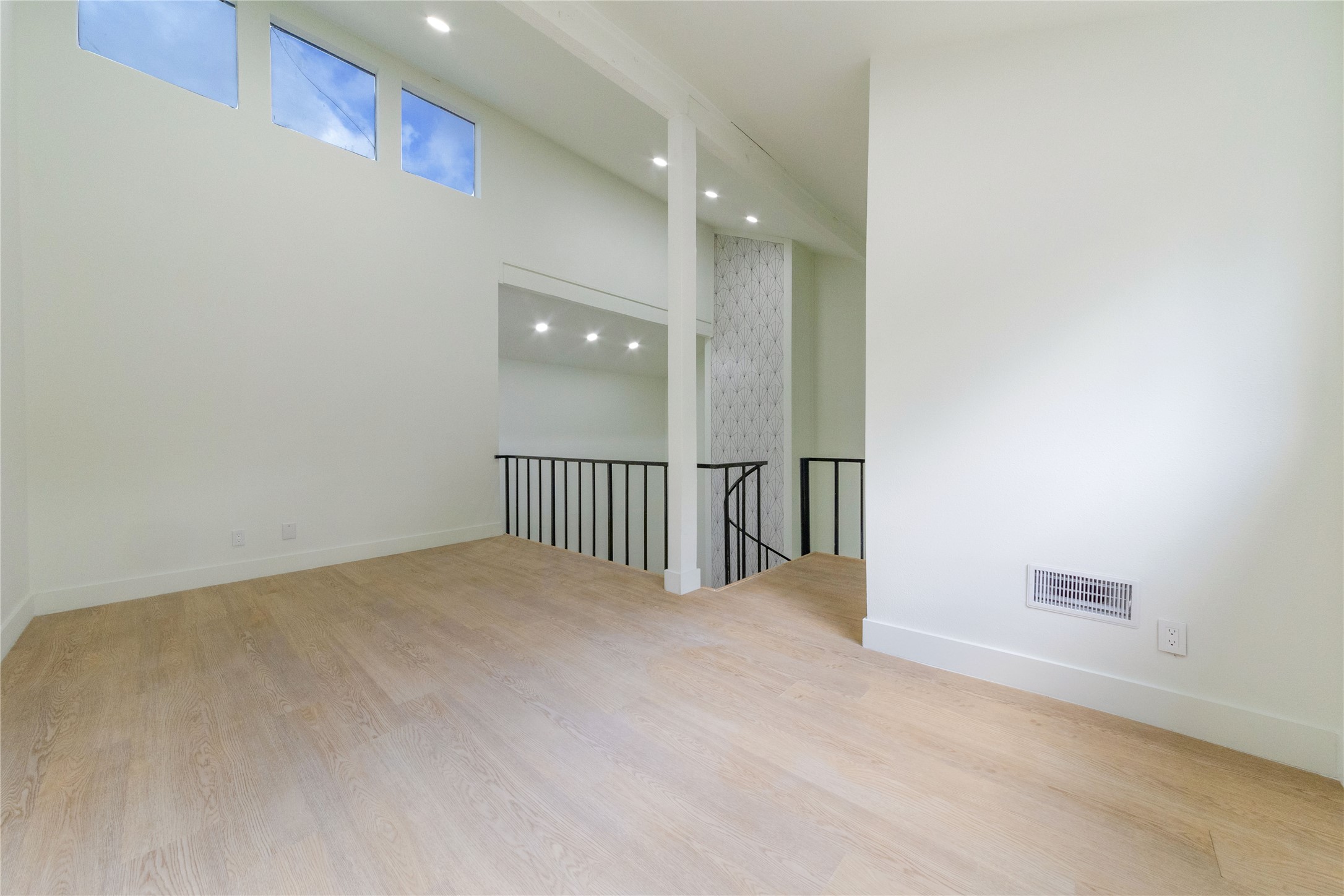 8807 Merion Circle Austin, TX 78754 - Photo 15 of 18 Natural light floods this versatile space, featuring sleek wooden floors and a striking modern staircase.
