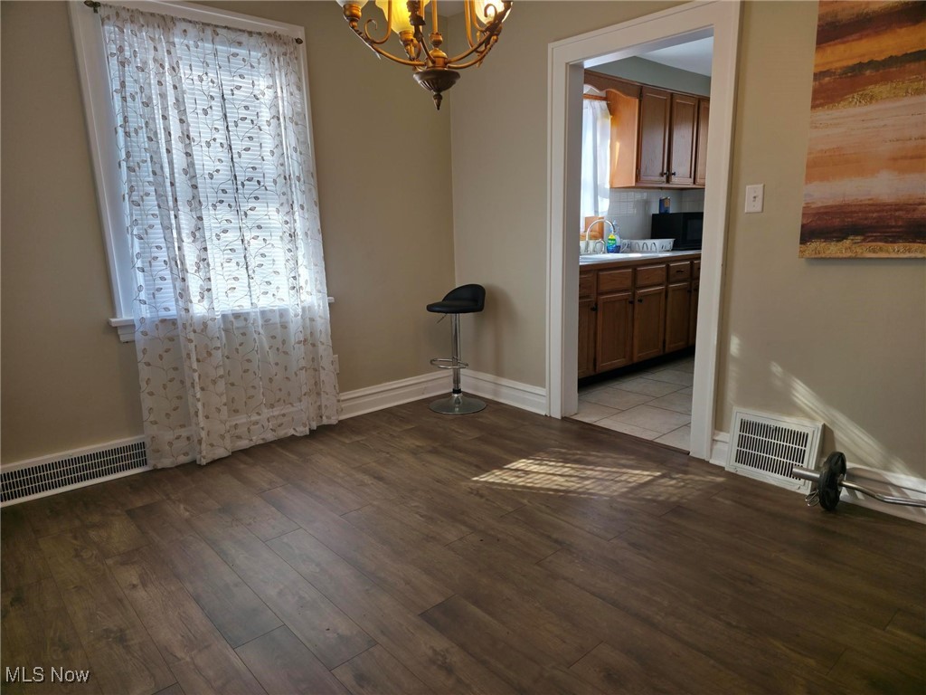 1425 Crescent Road Southwest Canton, OH 44710 - Photo 11 of 35 Unfurnished dining area featuring light wood finished floors and a chandelier