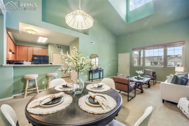 a dining room with furniture a large window and a chandelier